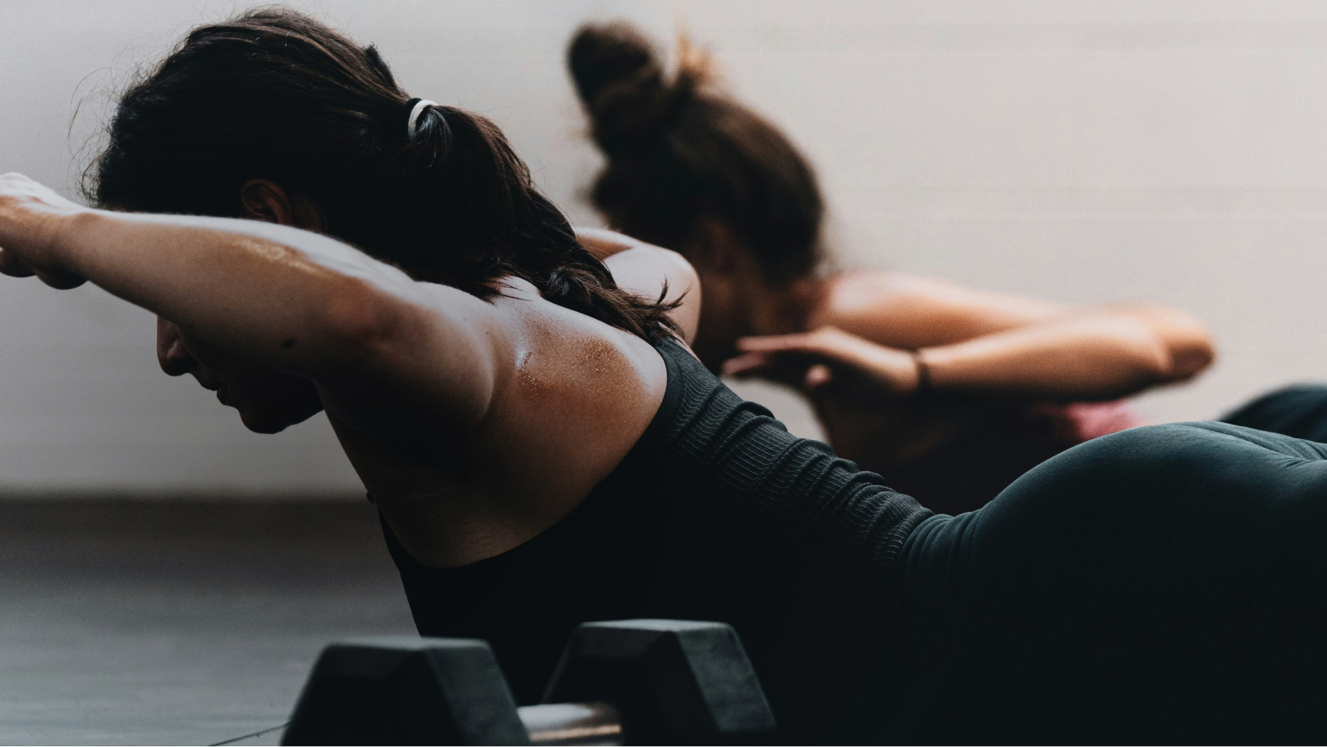 An image of a woman lying on an exercise mat while doing a fitness class.