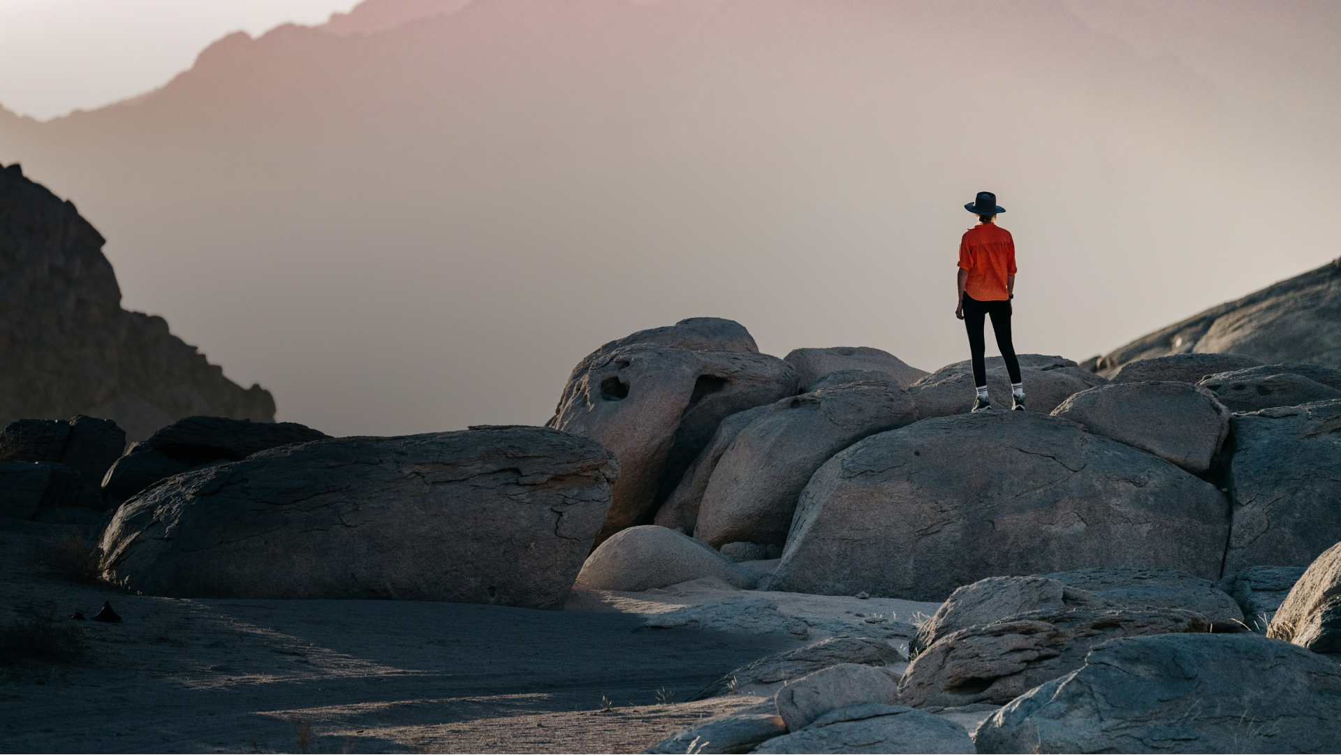 An image of a woman exploring over the rocks on a remote beach. 